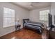 Cozy bedroom with hardwood floors, neutral walls, and two bright windows at 7532 Bay Port Rd # 18, Orlando, FL 32819