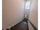 View down an interior staircase with dark treads, white risers and a striking arched window at 7532 Bay Port Rd # 18, Orlando, FL 32819