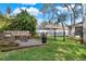 Backyard sitting area with wood bench, stone pavers, and view of lawn and black metal fence at 795 Sterling Chase Dr, Port Orange, FL 32128