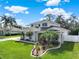 Charming two-story home with landscaped yard, palm trees, and blue skies, creating a welcoming curb appeal at 795 Sterling Chase Dr, Port Orange, FL 32128