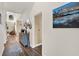 Hallway with wood floors leading to a living area, showcasing stylish decor and a glimpse of the staircase at 795 Sterling Chase Dr, Port Orange, FL 32128