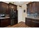 Kitchen showcasing stainless steel refrigerator, dark wood cabinets, and granite countertops at 795 Sterling Chase Dr, Port Orange, FL 32128