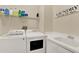 Clean laundry room featuring appliances, sink, and ample shelving for storage at 795 Sterling Chase Dr, Port Orange, FL 32128