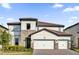 Beautiful two-story home featuring a three-car garage, tile roof, and stone accents at 7952 Wandering Way, Orlando, FL 32836