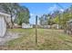 Large backyard with green grass, mature trees, and a white storage shed at 807 Vercelli St, Deltona, FL 32725