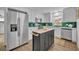 This bright kitchen features white cabinetry, a stainless steel refrigerator, and a butcher block island at 807 Vercelli St, Deltona, FL 32725