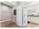 Hallway leading to a bathroom with granite countertops and white cabinets is displayed at 8163 Upper Perse Cir, Orlando, FL 32827