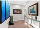 Hallway features neutral paint, modern art, and a glass console table at 8163 Upper Perse Cir, Orlando, FL 32827