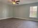 Bright bedroom featuring a ceiling fan, wood-look flooring and a window overlooking green space at 8315 Sw 135Th Street Rd, Ocala, FL 34473