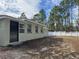 A well-maintained home exterior is showcased with a tidy lawn and a charming white fence in the background at 8315 Sw 135Th Street Rd, Ocala, FL 34473