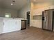 Well-lit kitchen boasts stainless steel appliances, white cabinetry, and wood flooring at 8315 Sw 135Th Street Rd, Ocala, FL 34473