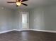 Open-concept living area with modern ceiling fan, decorative door, and wood-look flooring at 8315 Sw 135Th Street Rd, Ocala, FL 34473