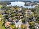 Expansive aerial shot of the property showcasing its location near a lake and surrounded by trees at 8413 Commander Cv, Winter Park, FL 32792