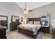 Spacious main bedroom featuring a large bed, ceiling fan, and coordinated furniture set at 8413 Commander Cv, Winter Park, FL 32792