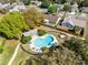 Aerial view of a kidney-shaped pool, surrounded by patio furniture, lush landscaping, and a black metal fence at 8413 Commander Cv, Winter Park, FL 32792