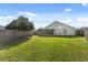 Expansive backyard with green grass, wood fence, and the home's exterior in the background at 8523 Fort Clinch Ave, Orlando, FL 32822