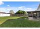 Spacious backyard with a wood fence and lush green grass extending to a screened-in porch at 8523 Fort Clinch Ave, Orlando, FL 32822