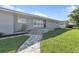 Close up on a gray home showcasing its beautiful stone walkway, and lush green grass and landscaping at 867 N Halifax Dr, Ormond Beach, FL 32176