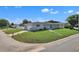 Charming single-story home featuring a well-manicured lawn and a gray brick facade, next to a quiet street at 867 N Halifax Dr, Ormond Beach, FL 32176