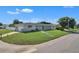 Charming single-story home featuring a well-manicured lawn and a gray brick facade, next to a quiet street at 867 N Halifax Dr, Ormond Beach, FL 32176