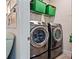 Functional laundry room with modern washer and dryer units, shelving, and space-saving design at 9360 Meadow Hunt Way, Winter Garden, FL 34787