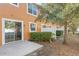 Townhouse patio with a sliding glass door, small green hedge, and plenty of space for entertaining at 9559 Silver Buttonwood St, Orlando, FL 32832