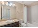 Neutral bathroom featuring a large mirror, single sink vanity, and bathtub with shower at 9559 Silver Buttonwood St, Orlando, FL 32832