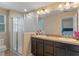 Neutral bathroom featuring a double sink vanity with dark cabinets, shower with glass door, and view into bedroom at 9559 Silver Buttonwood St, Orlando, FL 32832