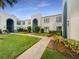 Exterior angle view of condominium buildings with blue archways and well maintained grassy courtyard at 1030 Plantation Dr # C6, Kissimmee, FL 34741