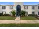 Exterior view of building with blue shutters, arched entry, small trees, and sidewalk at 1030 Plantation Dr # C6, Kissimmee, FL 34741