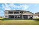 Expansive two-story home boasts a large lawn, covered lanai, and a balcony, ideal for outdoor entertaining and relaxation at 1191 Terralago Way, Kissimmee, FL 34746