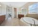 Bright bathroom featuring a soaking tub, double vanity, and lots of natural light at 1191 Terralago Way, Kissimmee, FL 34746