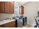 Functional laundry room with washer, dryer, sink, ample cabinet storage, and a window for natural light at 1191 Terralago Way, Kissimmee, FL 34746