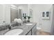 Well-lit bathroom with double sinks, granite countertops, and a shower with tile surround at 1206 Normandy Dr, Haines City, FL 33844