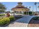 Community gazebo with a clock and a brick walkway surrounded by lush greenery, and a fountain at 1206 Normandy Dr, Haines City, FL 33844