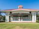 Community pavilion with a red roof and white columns, set on a green lawn at 1206 Normandy Dr, Haines City, FL 33844