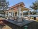 Outdoor picnic pavilion featuring picnic tables on a concrete slab, supported by columns and an awning, next to park trail at 1206 Normandy Dr, Haines City, FL 33844