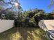 A fenced backyard features green space and shaded areas beneath lush trees at 1213 S Station Pl # 404, Orlando, FL 32827