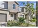 Townhouse exterior showcasing gray tones, a brick driveway, landscaping and an attached garage at 1213 S Station Pl # 404, Orlando, FL 32809