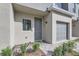 Close-up of a townhouse front entrance featuring brick walkway, gray door, garage, and window at 1213 S Station Pl # 404, Orlando, FL 32809