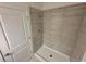 Stand-up shower with bright white tile and door at 1213 S Station Pl # 404, Orlando, FL 32827