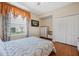 Bedroom with wood floors, a ceiling fan, closet and a window with decorative curtains at 126 Seville Chase Dr, Winter Springs, FL 32708