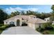 Charming home featuring a three-car garage, mature landscaping, and a light-colored exterior at 126 Seville Chase Dr, Winter Springs, FL 32708