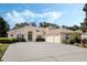 Spacious single-story home with a three-car garage, elegant arched entryway, and well-maintained landscaping at 126 Seville Chase Dr, Winter Springs, FL 32708