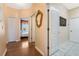 Bright hallway features wood and tile flooring and a decorative gold mirror on the peach colored walls at 126 Seville Chase Dr, Winter Springs, FL 32708