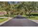 Scenic street view of the neighborhood, featuring mature trees and well-maintained landscaping at 126 Seville Chase Dr, Winter Springs, FL 32708