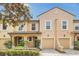 Charming two-story townhome featuring a tile roof, attached garage, and beautifully landscaped front yard at 1347 Benevolent St, Maitland, FL 32751