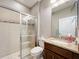 Bathroom featuring a glass-door shower, dark wood vanity with granite countertops, white toilet, and tile floors at 1374 Zeek Ridge St, Clermont, FL 34715