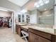 Bathroom featuring double vanity with granite countertops, a dressing table, and walk-in closet access at 1374 Zeek Ridge St, Clermont, FL 34715