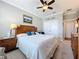 Bedroom with a wood headboard, ceiling fan, white double door closet, light gray walls, and carpeted floor at 1374 Zeek Ridge St, Clermont, FL 34715